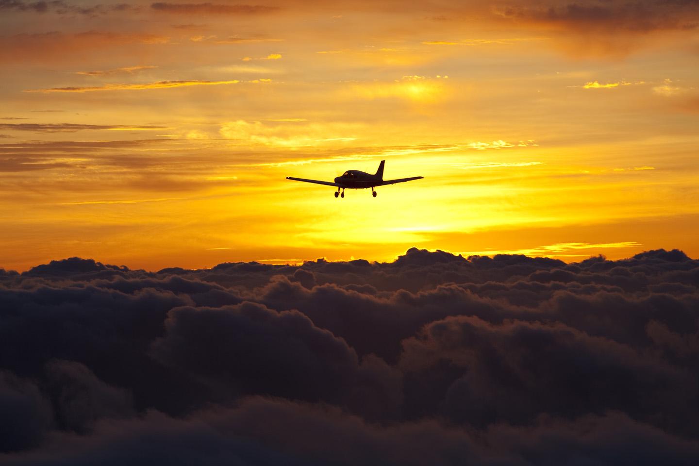 Plane flying through the sky during sunset